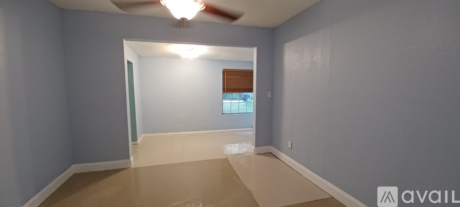 A room with a ceiling fan and a window.
