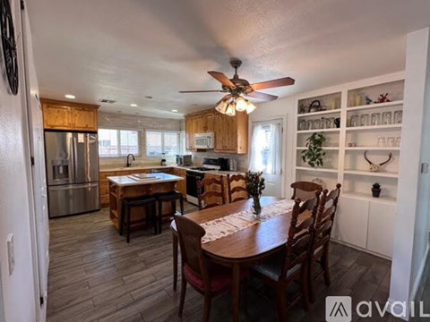 A kitchen with a dining table and chairs.