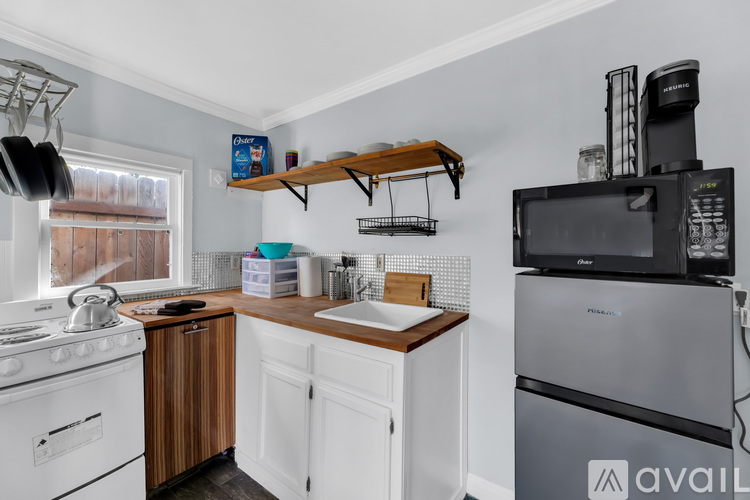 A kitchen with white cabinets and a wooden countertop.