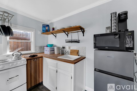 A kitchen with white cabinets and a wooden countertop.