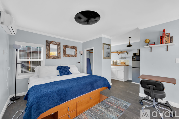 A bedroom with a bed, desk, and chair.