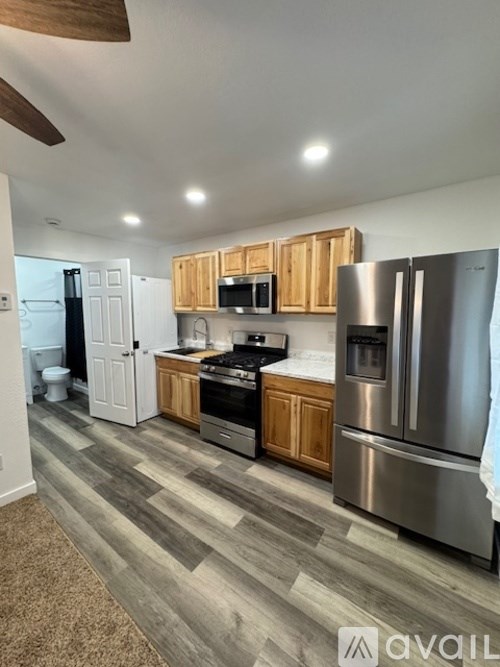 A kitchen with wooden cabinets and a stainless steel refrigerator.