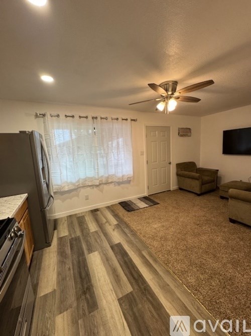 A living room with a brown carpet and a wooden floor.