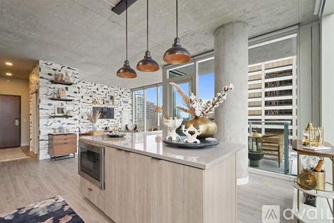 A modern kitchen with a stone wall and a marble countertop.
