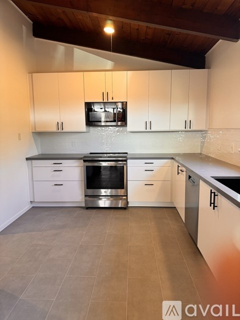 A kitchen with white cabinets and a stainless steel oven.
