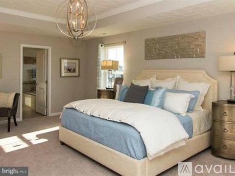 A bedroom with a large bed and a chandelier.