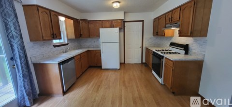 A kitchen with wooden cabinets and a white refrigerator.