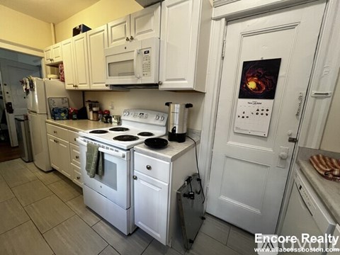 A white kitchen with a stove and oven.