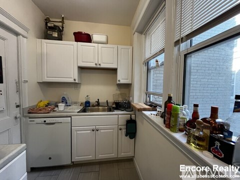 A kitchen with white cabinets and a sink.