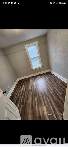 A room with wooden flooring and a skylight window.