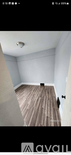 A room with wooden flooring and white walls.