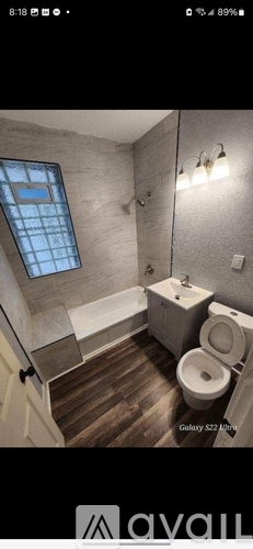 A bathroom with a toilet, sink, and a window.