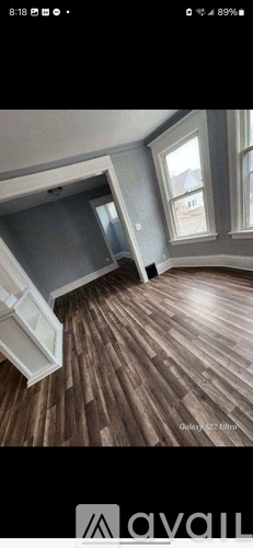 A room with wooden flooring and a window.