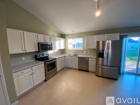 A kitchen with white cabinets and stainless steel appliances is available for rent.