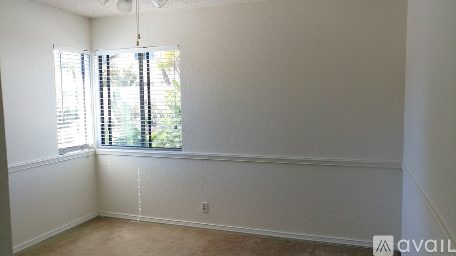 A room with a window and a fan on the ceiling.
