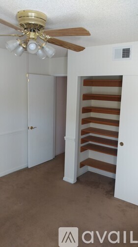 A room with a ceiling fan and a white door.