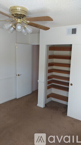 A room with a ceiling fan and a white door.
