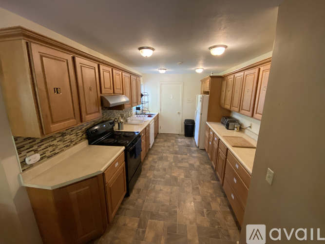 A kitchen with wooden cabinets and a checkered floor.