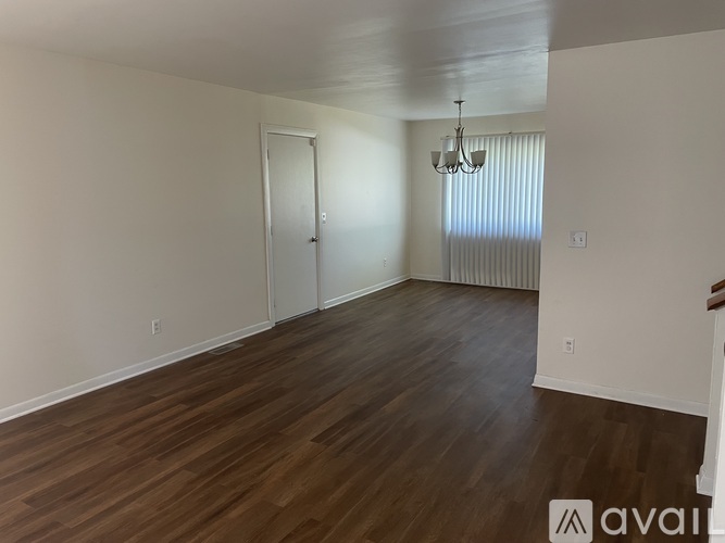 A room with wooden flooring and a chandelier.