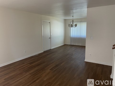 A room with wooden flooring and a chandelier.