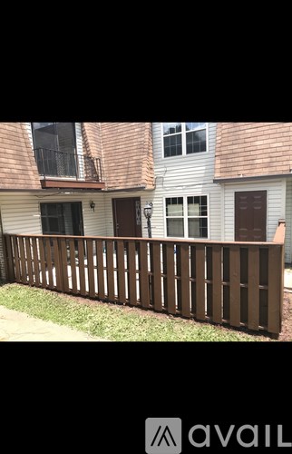 A brown wooden fence in front of a house.