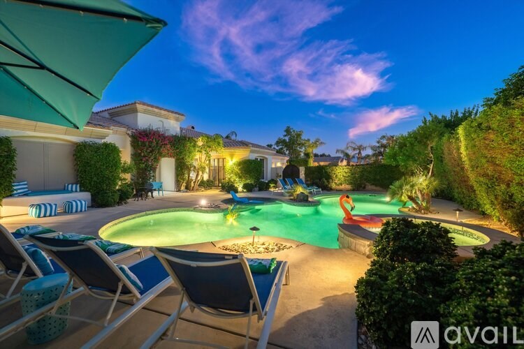 A backyard with a pool and lounge chairs.