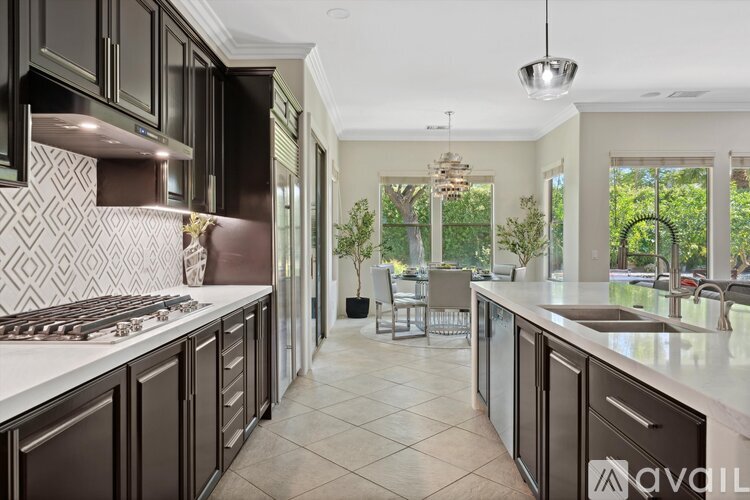 A modern kitchen with dark brown cabinets and a white countertop.