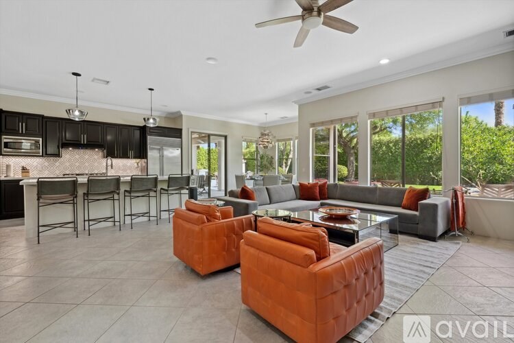 A modern living room with a kitchen area in the background.