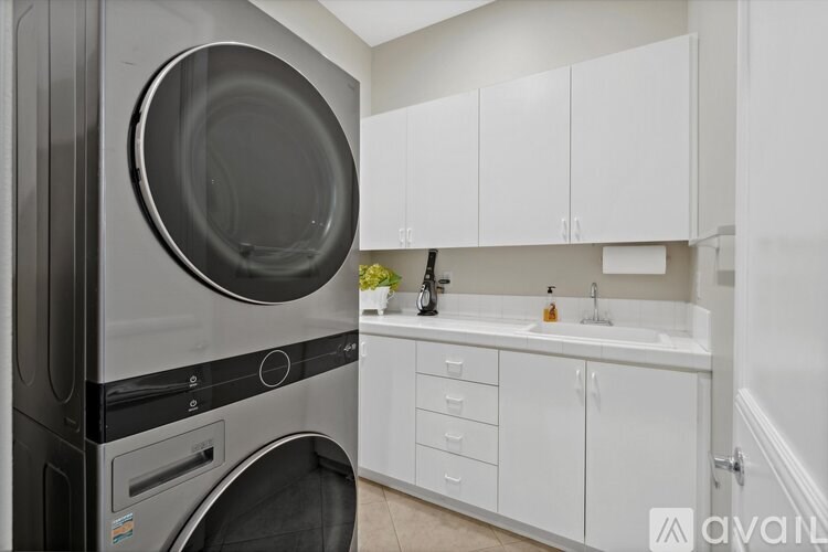 A modern kitchen with a stainless steel dishwasher and white cabinets.