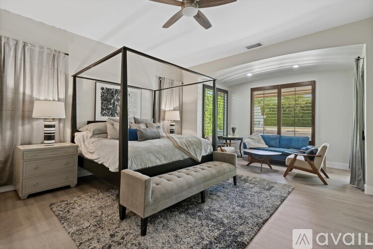 A bedroom with a four poster bed and a blue couch.