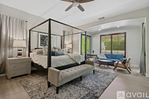 A bedroom with a four poster bed and a blue couch.
