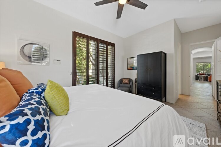 A bedroom with a large bed and a ceiling fan.