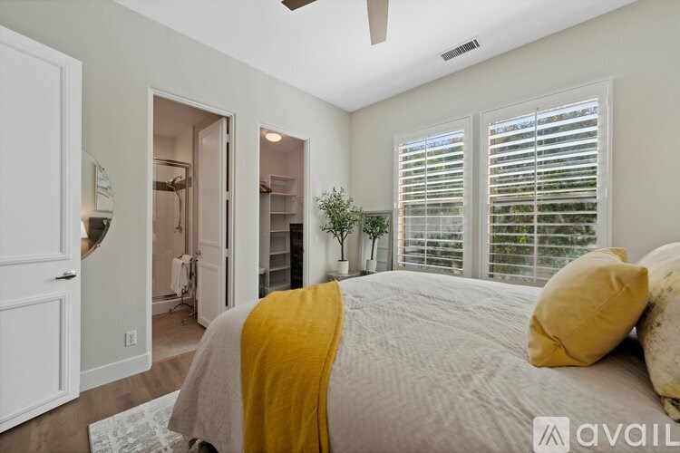 A bedroom with a bed covered in a yellow blanket.
