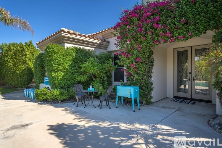 A house with a blue table and chairs outside.