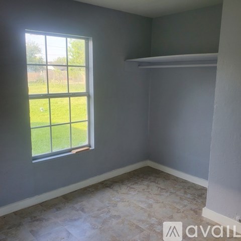 A room with a large window and a tiled floor.