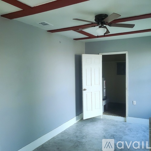 A room with a ceiling fan and a door.