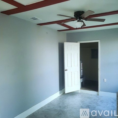 A room with a ceiling fan and a door.