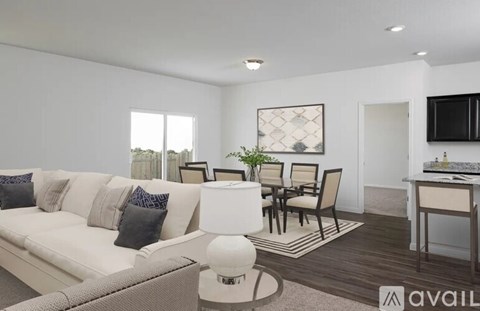 A modern living room with a white sofa, a dining table set, and a kitchen area in the background.