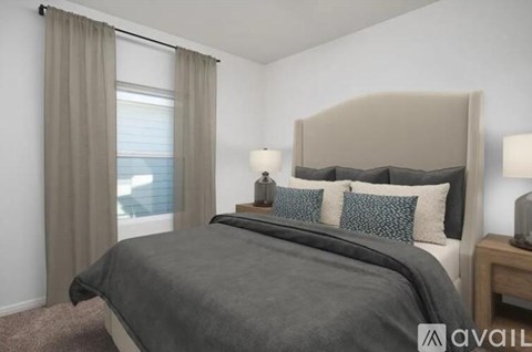 A bedroom with a large bed and a window with curtains.