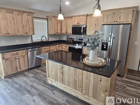 A kitchen with wooden cabinets and a black countertop.