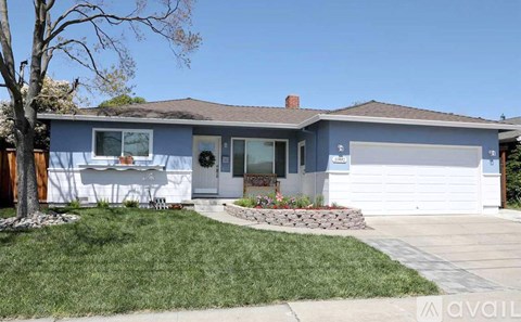 A house with a blue exterior and a white garage door.