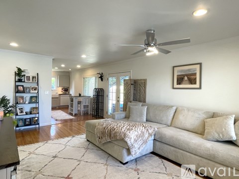 A living room with a beige couch and a rug.