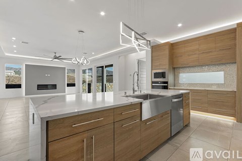 A modern kitchen with wooden cabinets and a marble countertop.