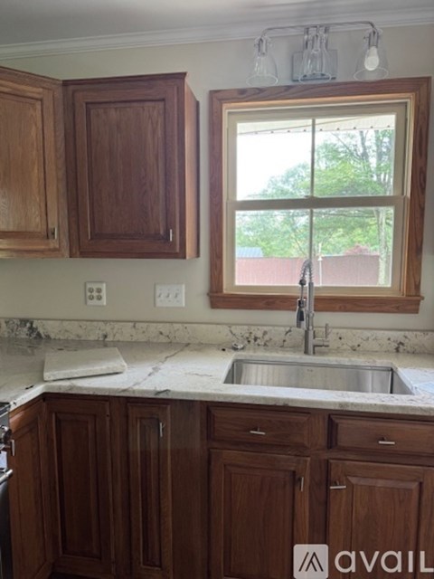 A kitchen with wooden cabinets and a marble countertop.