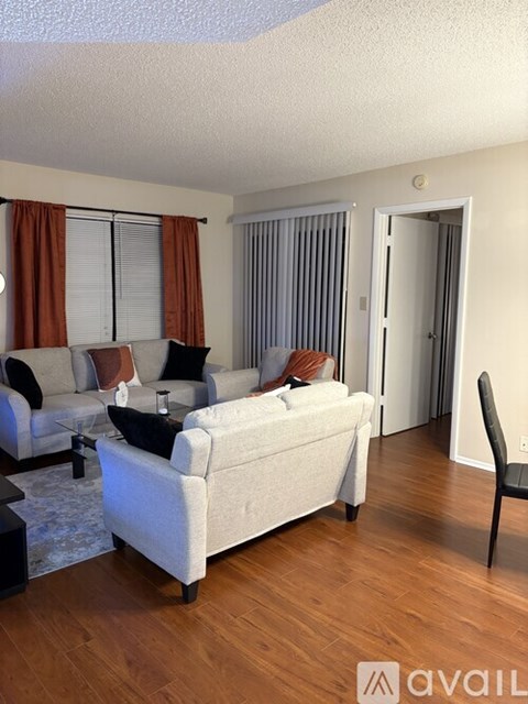 A living room with a white couch and a black chair.