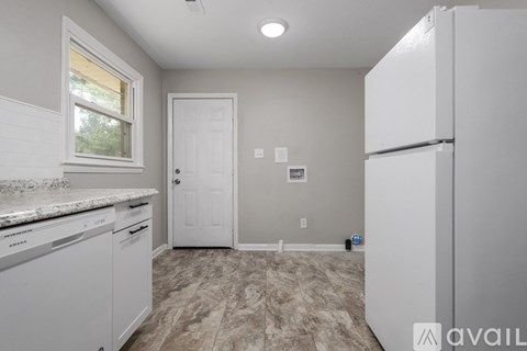 A kitchen with a white fridge, dishwasher and cabinets.