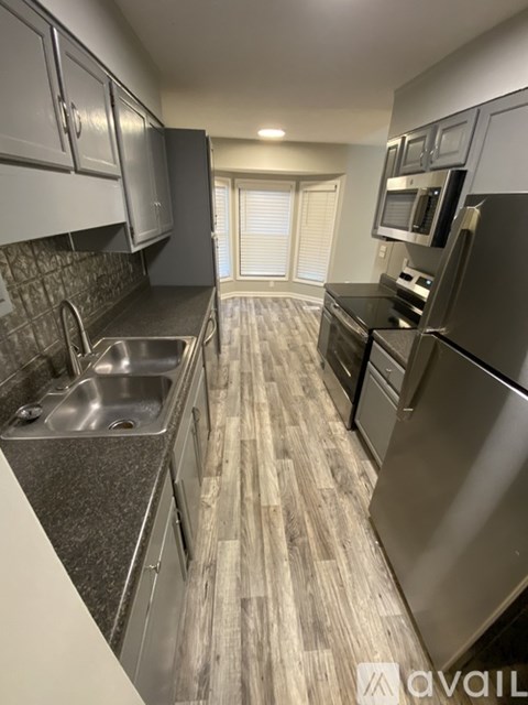 A kitchen with a sink, stove, and refrigerator.