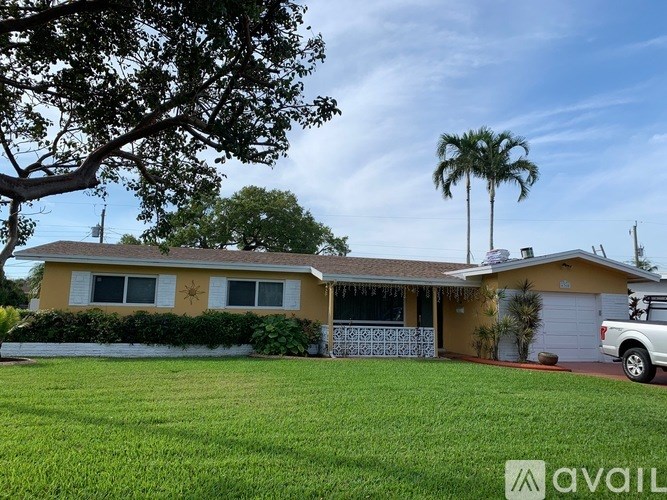 A house with a white car parked in front.