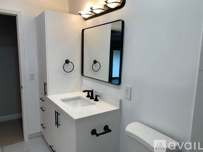 A bathroom with a sink, mirror, and toilet.