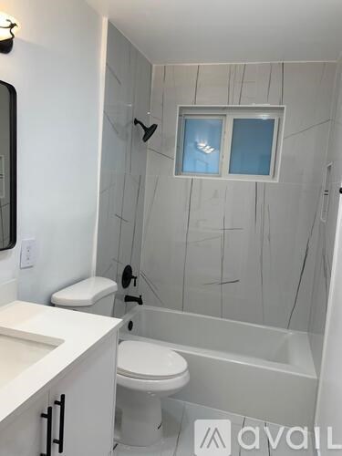 A white toilet sits next to a walk-in shower.